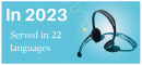 Blue background. On the right is a black headphone set. Text says, In 2023. Served in 22 languages.